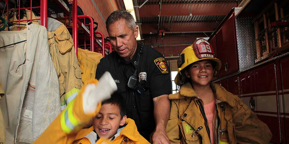kids with fireman dressed in fire gear