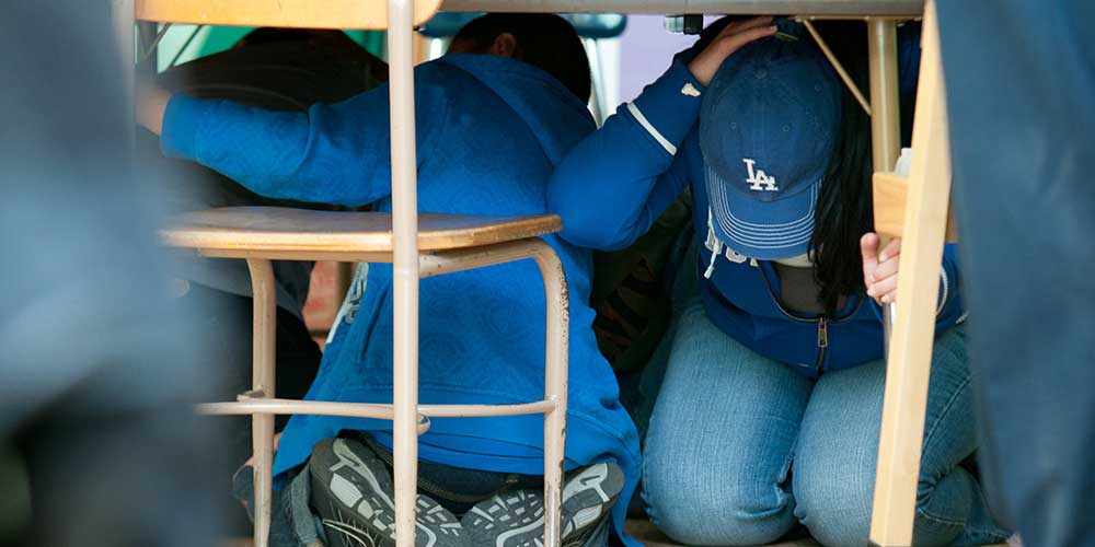 kids ducking and covering under table