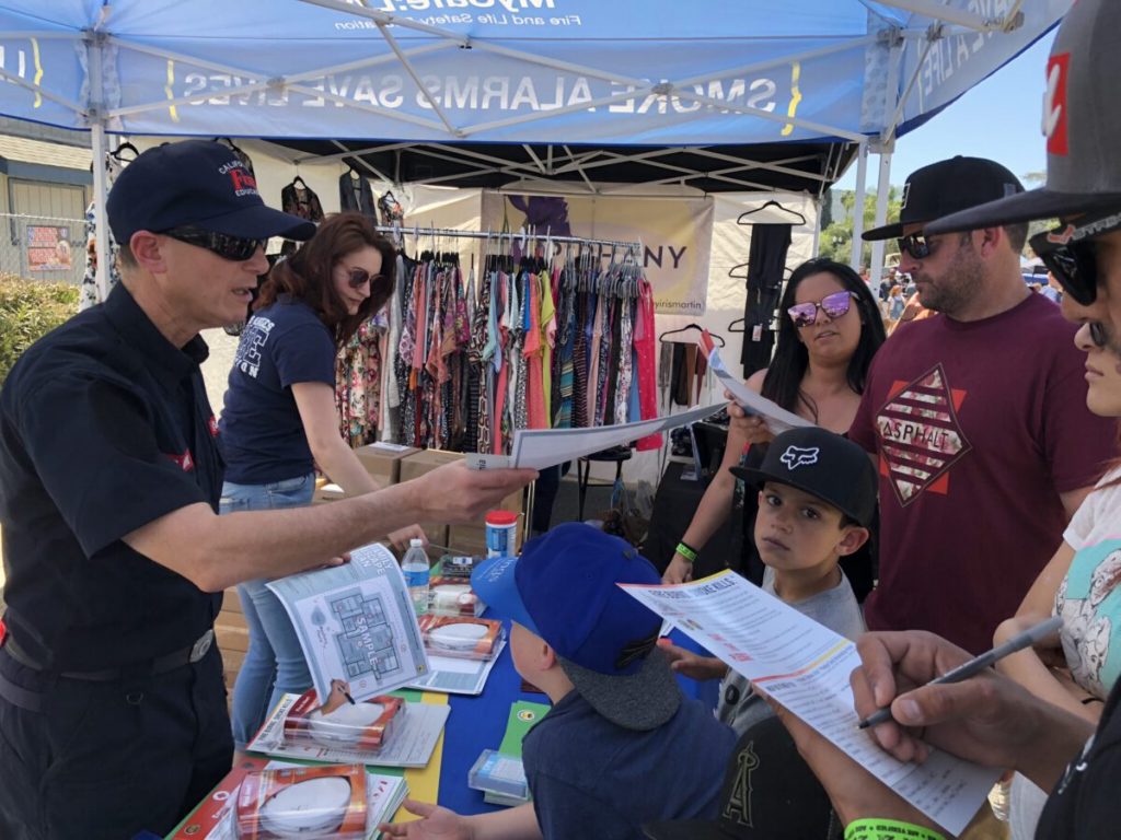 People gather to collect fire safety materials during a public safety fair